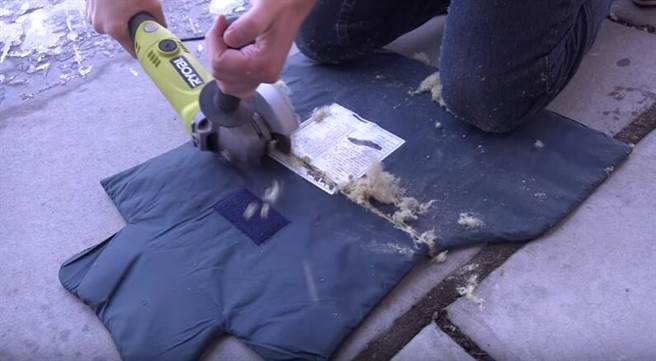 他们把防弹衣放在地面上用切割工具将其切割开，准备一探究竟。